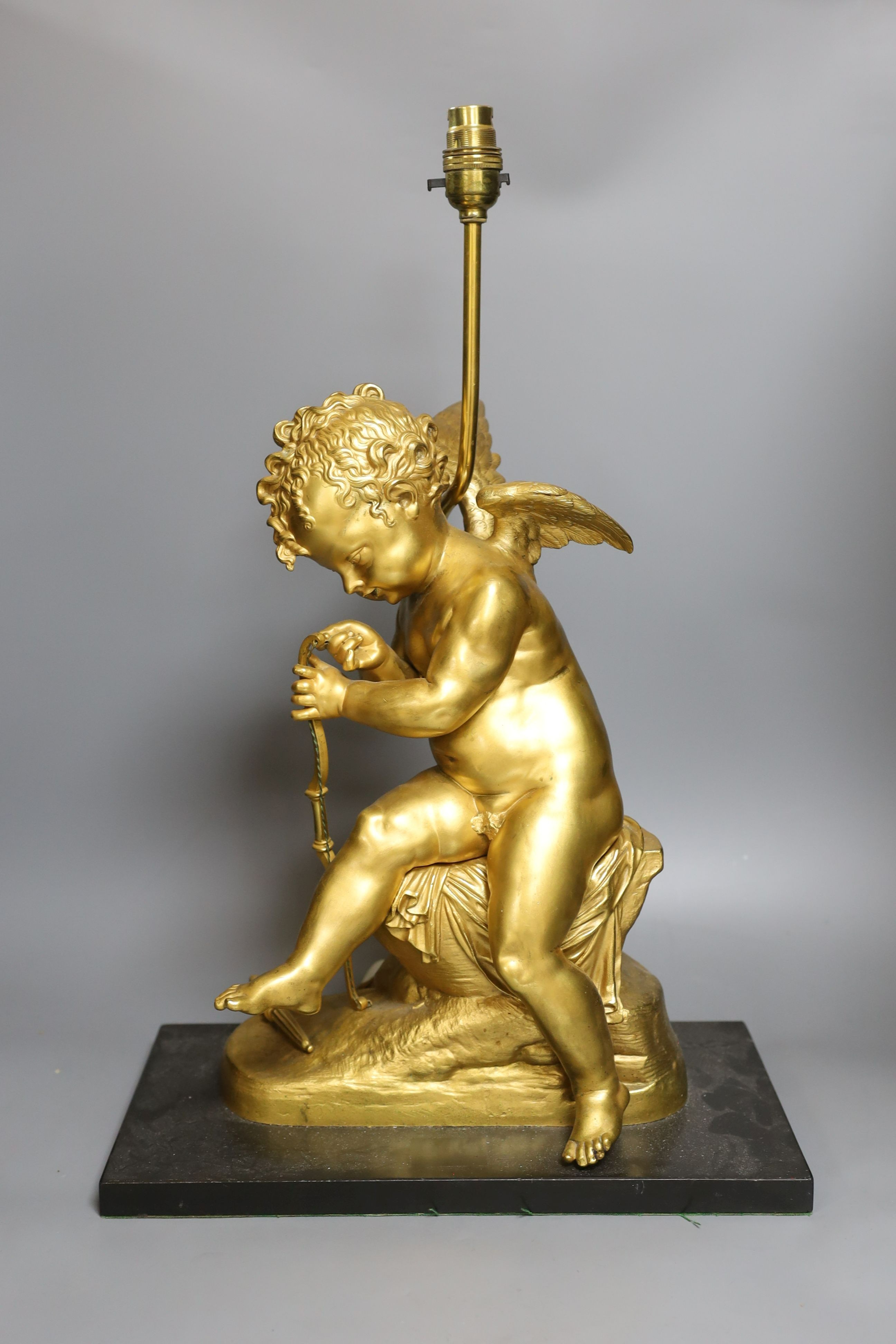 A gilt bronze seated Cupid figural lamp on mount - 58cm tall